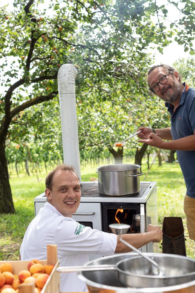 Patrick Friedrich und Jimmy Schlager beim Marillentraum Marmelade kochen im Obstgarten der Weinkultur Preiss fotografiert von Fotografin Verena Pelikan