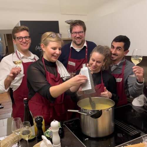 Menschen haben Spass beim Firmenkochkurs als Teambuildling Event im Kochstudio SchlossStudio in Ebenthal im Bezirk Gaenserndorf