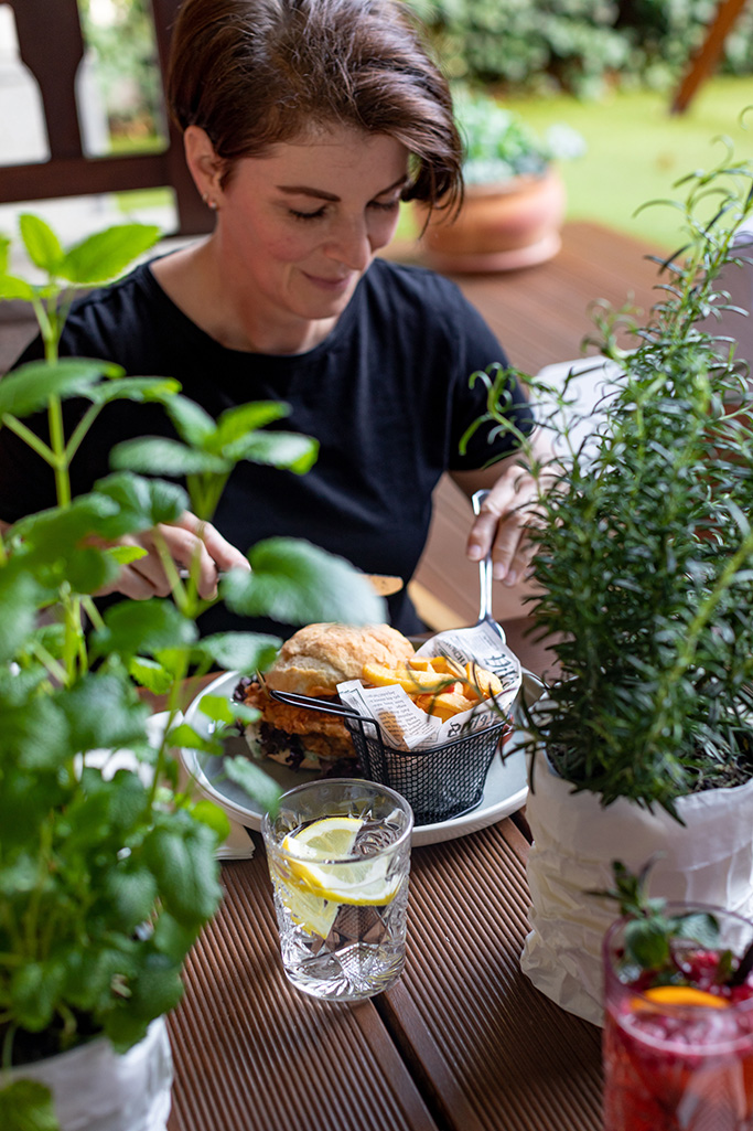 Frau beim Burger Essen im Gasthaus Garten fotografiert von Verena Pelikan 
