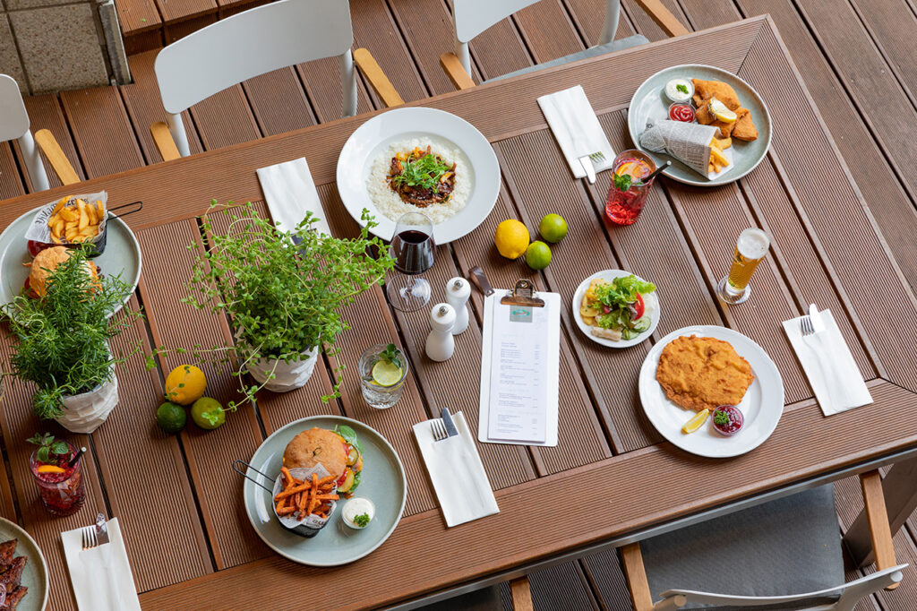 Gedeckter Tisch mit warmen Speissen und Getraenken im Gastgarten des Restaurant 